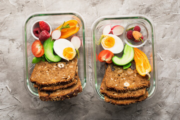 Lunch snack with you container. Slices of bread, fruits, berries, an egg for a snack. Top view.