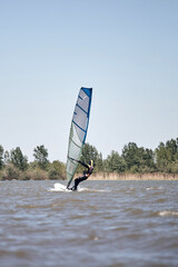 Windsurfer surfing on a windy summertime day at the river.