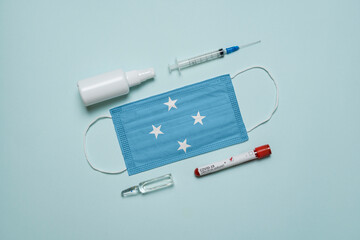 Blood tube for test detection of virus Covid-19 Omicron Variant with positive result, medicine mask with Micronezia flag superimposed and vaccine.  New Variant of the Covid-19 Omicron