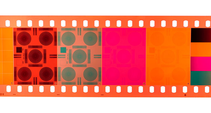 Color negative 35mm film stripes stacked on a lightbox.	                  