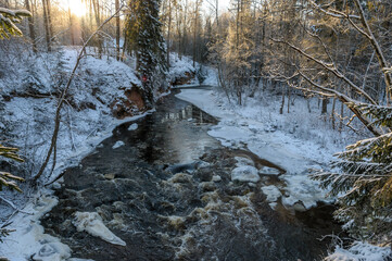 Winter landscape over river at cold sunrise