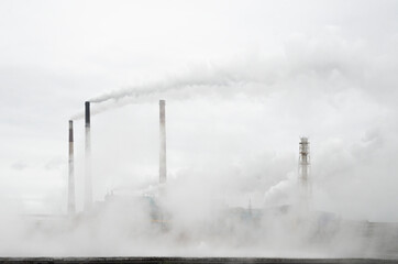Smoke from the chimneys of a metallurgical plant rises into the sky. Everything is in smoke. Carbon...