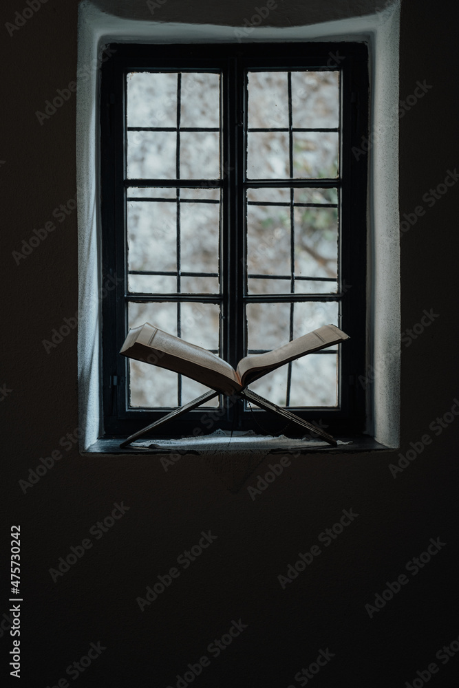 Poster vertical shot of an open book in front of the window