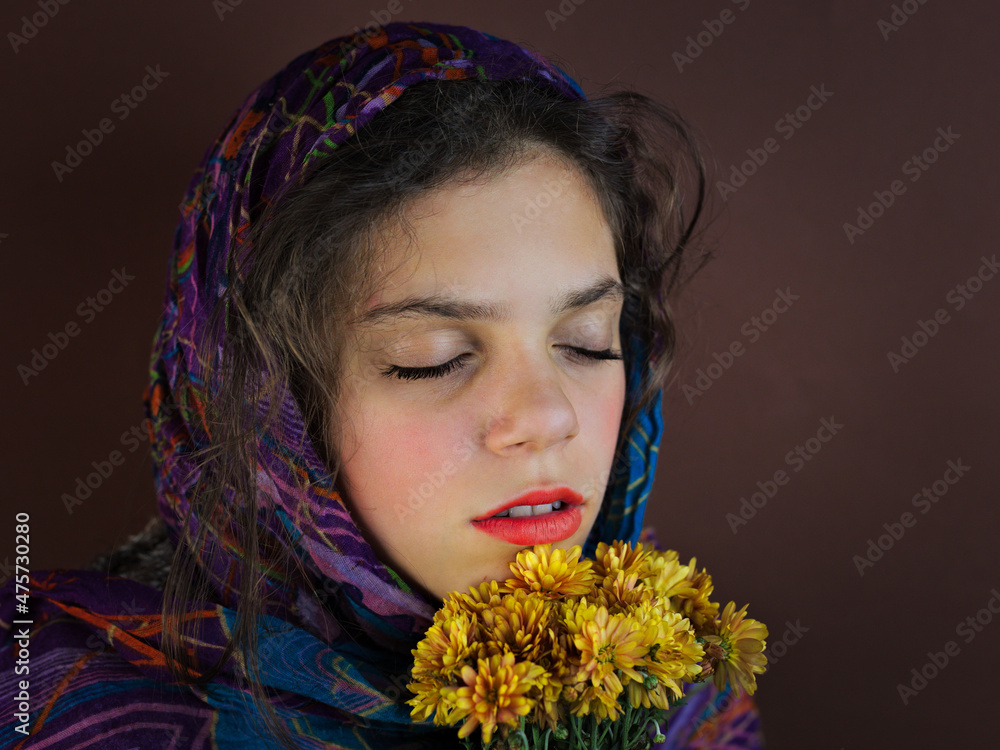 Sticker Portrait of a caucasian girl covering the head with a scarf on a dark background