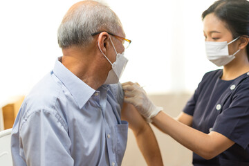 Obraz premium Medical worker or nurse perform a vaccine injection to senior Asian man in clinic or medical facility.