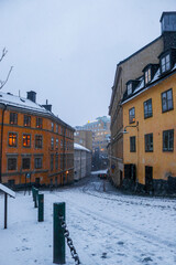 Fototapeta premium Snowy Swedish street and buildings at sunset, Södermalm, Stockholm, Sweden.