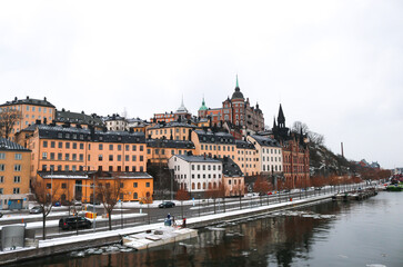 Fototapeta na wymiar Colourful buildings along the snowy riverside in the centre of Stockholm, Sweden.