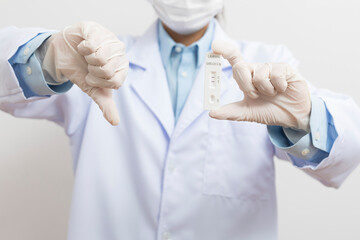 Fototapeta premium The doctor showing Covid-19 positive test result of the antigen rapid test kit on white background,Coronavirus infectious protect concept. 