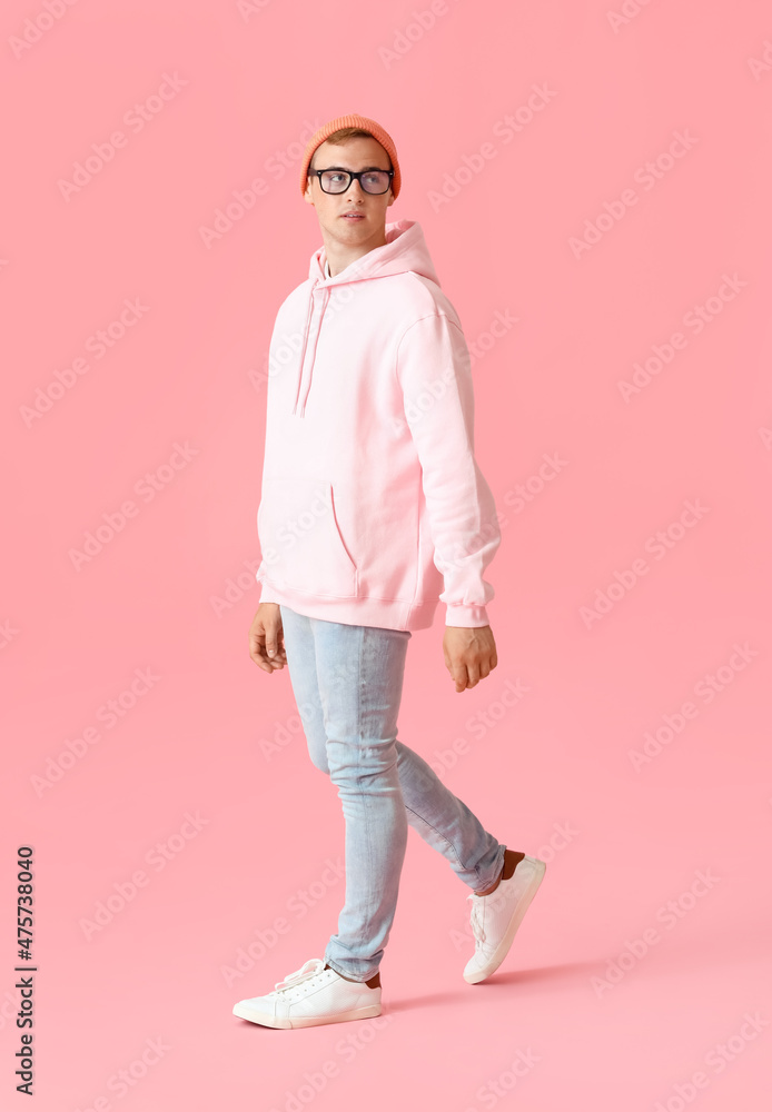 Wall mural Young guy in stylish hoodie on color background - Wall murals