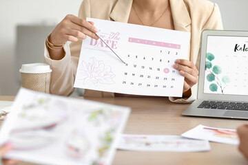 Female wedding planner discussing ceremony with clients in office