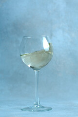 champagne flute with splash on the sand against the background of the old wall