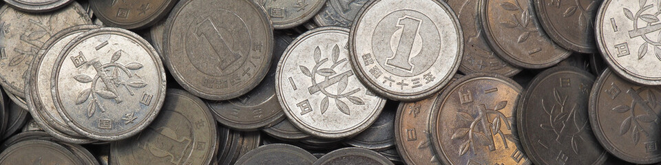 Surface of Japanese 1 yen coins. Scratched money from circulation. Close-up. Banner on the theme of the economy finance or banks in Japan. Macro