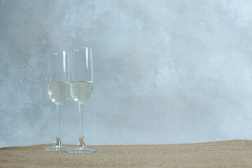 stylish minimalistic look of champagne flutes on the sand. on the eve of the holiday