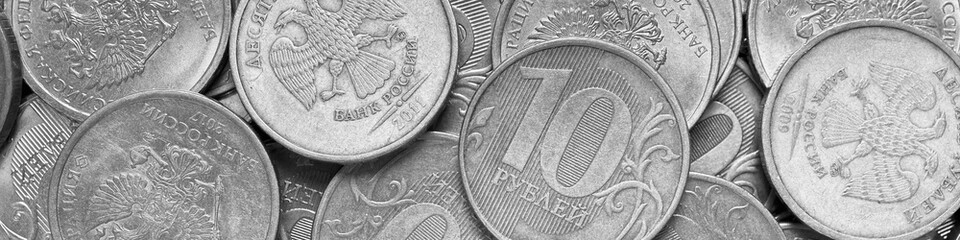 Surface of many Russian coins of 1 one ruble. Black and white banner. Light headline on the theme of economy, finance and the central bank of Russia. Macro