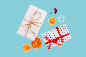 Christmas composition with two crafted gift, dried orange and wood star. Natural minimal eco, zero waste, new year concept, top view, flat lay, isolated, copy space on blue background