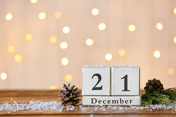 Calendar with date of winter solstice on light background with blurred lights