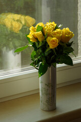Yellow rose flowers in a bouquet in a vase.