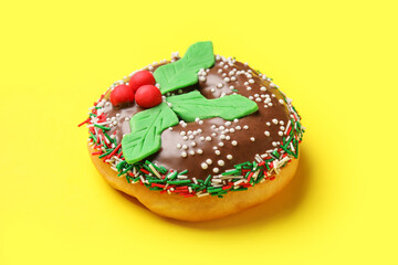 Tasty Christmas donut on yellow background