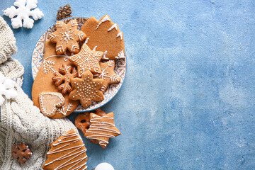 Plate with tasty gingerbread cookies on blue background