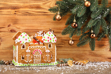 Fototapeta na wymiar Beautiful gingerbread house and Christmas decor on wooden background