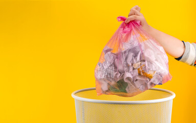 boy holding full garbage bag on yellow background, closeup. Space for text