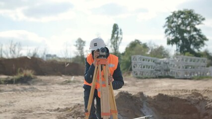 An engineer surveyor takes measurements at the construction of a transformer substation