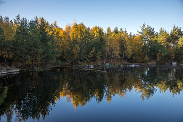 Fototapeta na wymiar autumn sunny morning near the flooded quarry