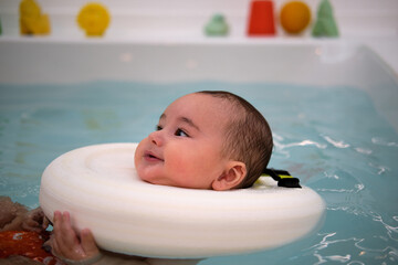Baby enjoying in the jacuzzi. Spa for babies. Hydrotherapy session for children. Baby swimming