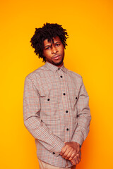 young handsome african american guy student posing cheerful and gesturing on yellow background, lifestyle people concept
