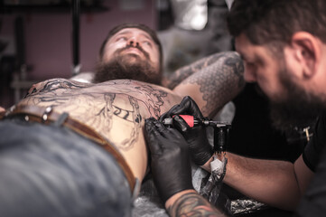 Tattooist making tattoo in salon