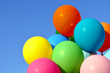bunch of multicolored balloons in the city festival on clear blue sky background
