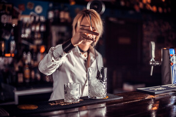 Portrait of girl barman demonstrates his professional skills on the bar