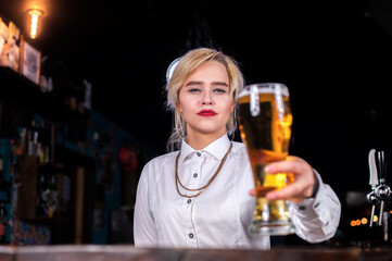 Sweet girl tapster places the finishing touches on a drink