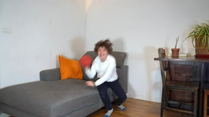 Son boy child 7 years old playing football soccer alone in apartment during Covid-19 Coronavirus lockdown quarantine home - play together lifestyle family in living room VENEZIA