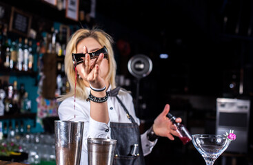 Girl bartender mixes a cocktail at the beerhall