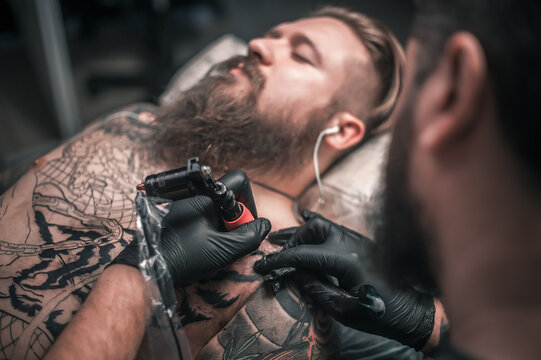Tattoo artist showing process of making a tattoo