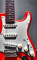 Fototapeta na wymiar Red electric guitar fretboard and body on gray background