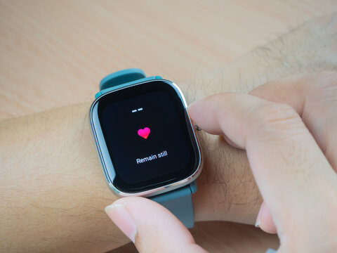 people measuring heart rate by green smartwatch health sensor for analyzing and connecting mobile app
