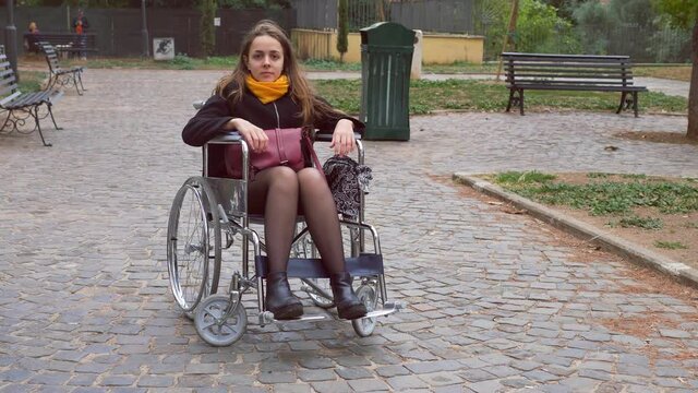 positivity, hope - young woman using wheelchair smiles confident at camera