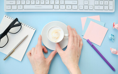 Beautiful flatlay arrangement of woman's work desk with pink laptop, cardboard, hortensia, glasses...