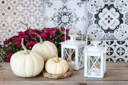 Autumn home decorations in scandinavian style. White baby boo pumpkin and hay wreath.