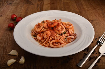 Spaghetti with calamary, octopus and shrimps in white plate