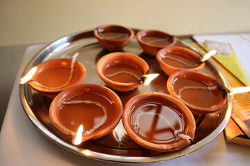 a silver tray of lighted Hindu diyas Diwali