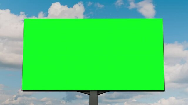 Timelapse - blank green billboard or large display and moving white clouds against blue sky - front view. Time lapse, advertising, green screen, template, mock up, copy space and chroma key concept