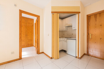 Apartment with small kitchen, bedroom with pine wood wardrobe and white tiles