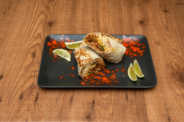 The Mexican burrito consists of a cylindrical rolled wheat flour tortilla filled with ingredients and is usually accompanied by refried beans, in this case with chicken and lime tinga.