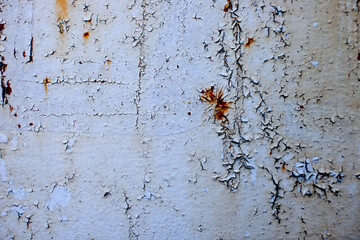 Rusty metal wall painted with paint. Rusty metal background with streaks of rust.