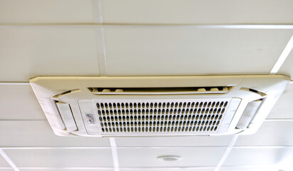 cassette type air conditioner mounted on ceiling wall. Air duct on ceiling in farmacy store. Air...