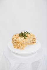 Napoleon cake in a cut on a white tray isolated on a white background. Cake of puff pastry with sour cream. Copy space. 