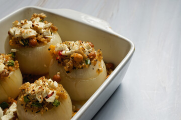 Stuffed onions, with bulgur and vegetables, in a baking dish. With copy space. 